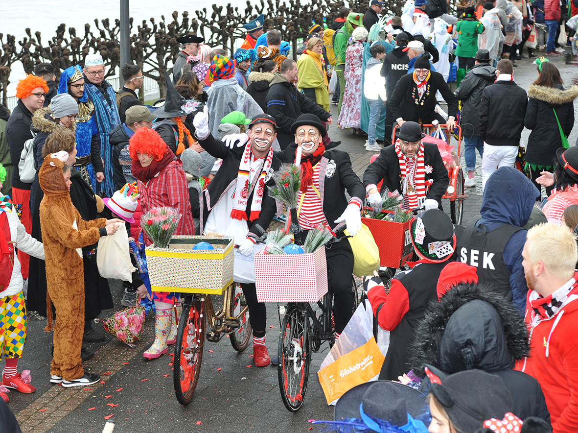 Eine Gruppe kostümierter Menschen nimmt am 19. Februar 2023 mit dem Fahrrad am Porzer Rosensonntagszug teil.